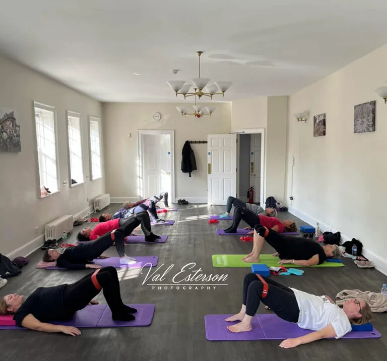 Pilates class performing a shoulder bridge